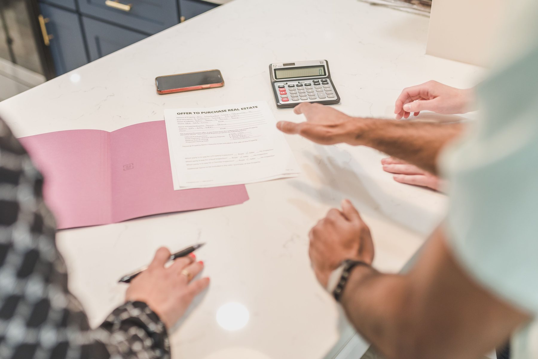 Reviewing title deed and project documents, hands over a desk