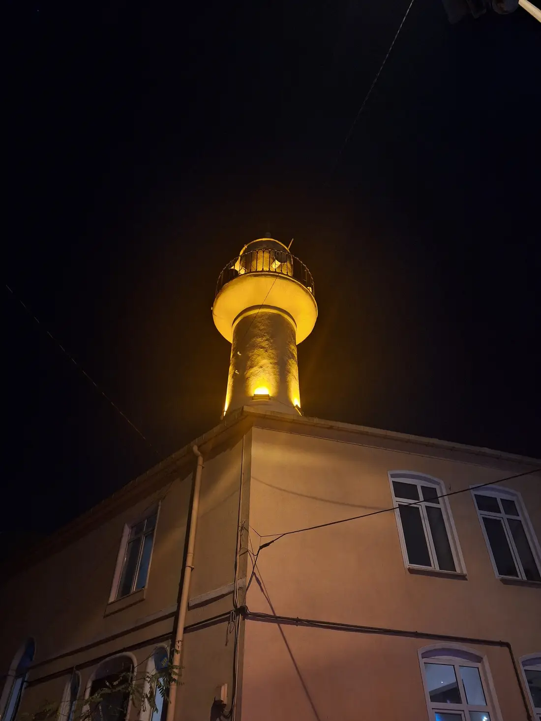 The minaret of Tomtom Kaptan Mosque lit up at night