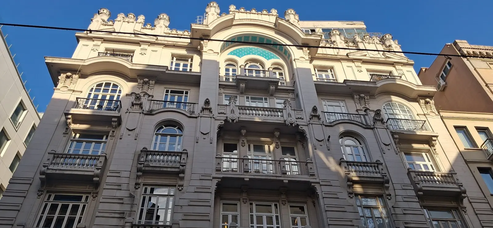 The balconied façade of Mısır Apartmanı with its mosaic arch